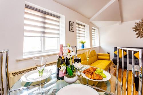 a living room with a glass table and a yellow couch at Exclusive City Centre Apartment in Newcastle upon Tyne