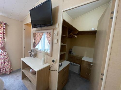 a small room with a tv on top of a bedroom at Luxury Lakeside Lodge L2 with Hot tub situated at Tattershall Lakes Country Park in Tattershall