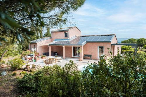 una casa de ladrillo con paneles solares. en Au jardin des gallinettes location villa piscine privée Carcassonne, en Alairac