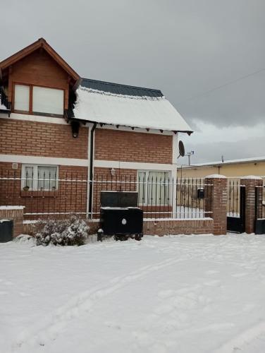 a house covered in snow with a fence at Valle Florido 2 in Trevelin