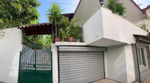 a white house with a gate and a garage at Christina's house with 2 bedrooms and free parking in Gjirokastër