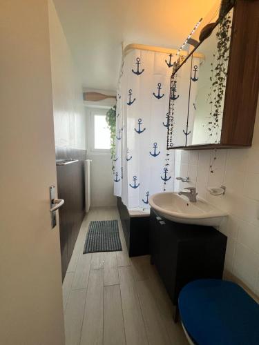 uma casa de banho com um lavatório e uma cortina de chuveiro com âncoras em 1 bedroom apartment - business trip em Nyon