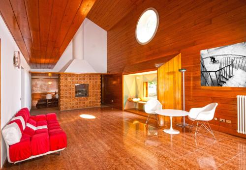 Villa di design con grande parco في تريفيزو: غرفة معيشة مع أريكة حمراء وطاولة