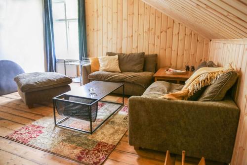 a living room with two couches and a coffee table at Lakeside Guesthouse in Ramvik