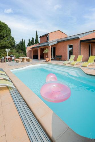 - une piscine avec un frisbee rose dans l'établissement Au jardin des gallinettes location villa piscine privée Carcassonne, à Alairac