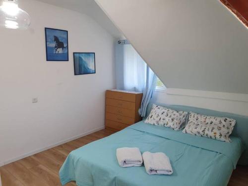 1 dormitorio con 1 cama azul y 2 toallas en ירוק בגולן, en Katzrin