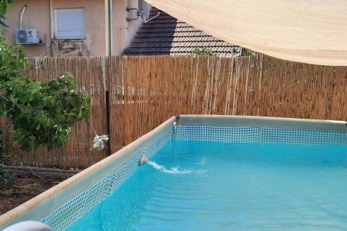 a swimming pool in front of a wooden fence at ירוק בגולן in Qasrîne