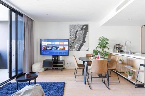 Luxurious 2 Bed City Scape Retreat with Rooftop في بريزبين: غرفة معيشة مع طاولة وتلفزيون