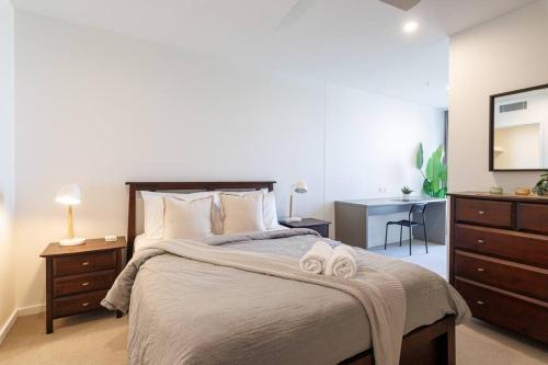 a bedroom with a bed with two towels on it at Luxurious 2 Bed City Scape Retreat with Rooftop in Brisbane