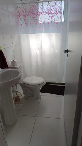 a bathroom with a toilet and a sink and a window at Apto Cenário de Montanha in Araras Petropolis