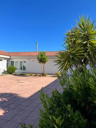 um edifício branco com palmeiras em frente em #1 HABITACIÓN DOBLE AYAMONTE em Ayamonte