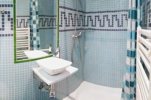 y baño de azulejos azules con lavabo y ducha. en Madrid Centre! La Latina - Plaza Mayor, en Madrid