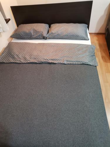two beds in a bedroom with a rug at Quiet central studio in Pazardzhik