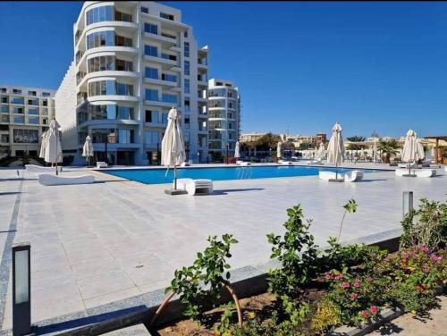 uma piscina com guarda-sóis e um edifício em Scandic Resort Hurghada em Hurghada