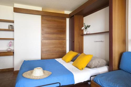 ein Schlafzimmer mit einem Bett mit Hut darauf in der Unterkunft Jardin de la cote d'azur in Saint-Mandrier-sur-Mer