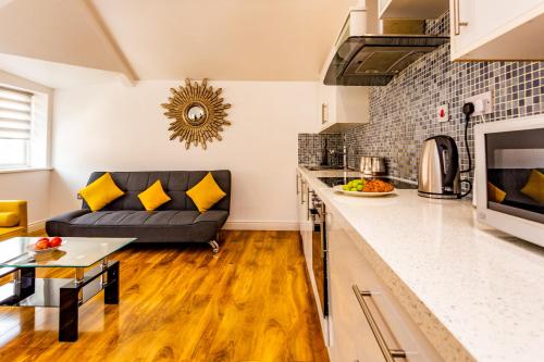 a kitchen and a living room with a couch at Exclusive City Centre Apartment in Newcastle upon Tyne