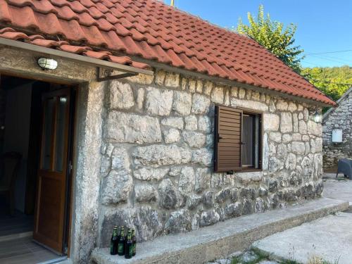 um edifício de pedra com um telhado vermelho e uma porta em Stone house em Cetinje
