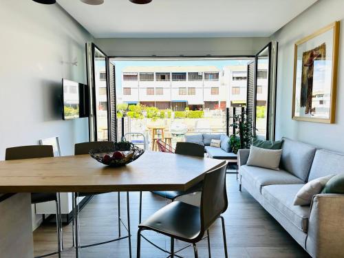 un soggiorno con tavolo e divano di Marina Dream House a Lignano Sabbiadoro