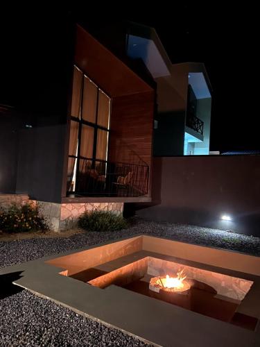 a fire pit in front of a house at night at CHALE VILAALICE in Monte das Gameleiras