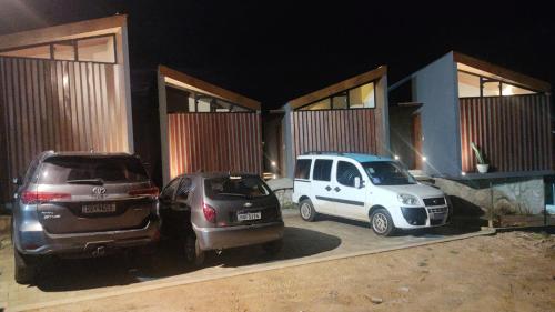 three cars parked in front of a building at night at CHALE VILAALICE in Monte das Gameleiras