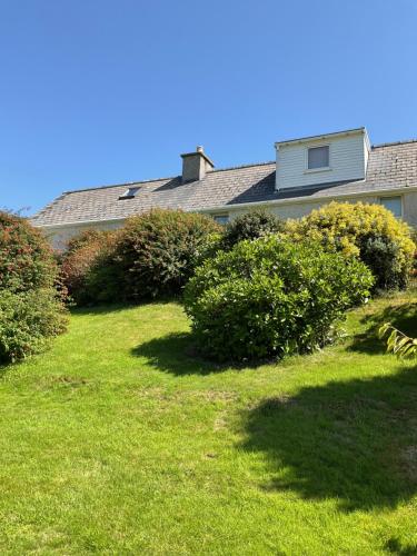 a house with a yard with green grass and bushes at 6 Calbost in Calbost