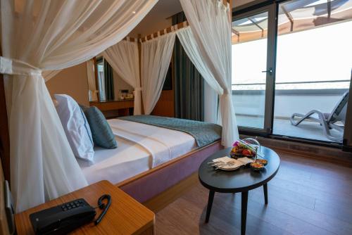 a hotel room with a bed and a table with a table at Palm Hills Bodrum Hotel in Bodrum City