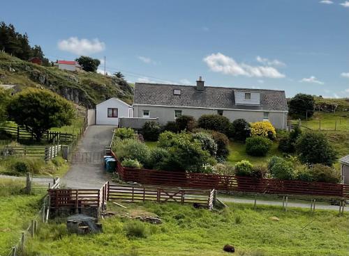 a house on a hill with a fence in front of it at 6 Calbost in Calbost