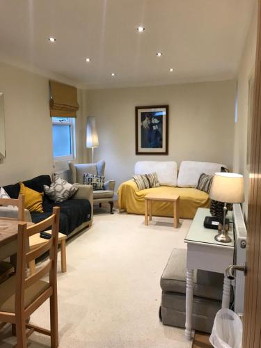 a living room with a couch and a table at Stylish & spacious 3 bed Victorian house sleeps up to 7 - near O2, Museums, Excel, Mazehill station 12 mins direct into London Bridge in London