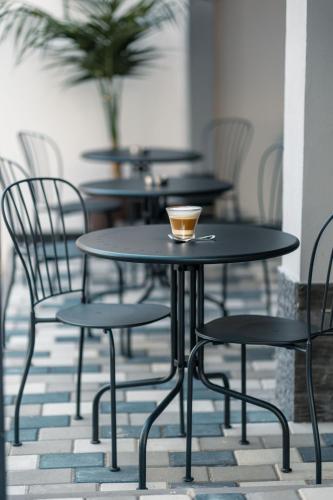 a table and chairs with a cup of coffee on it at ADAMZ in Vama Veche