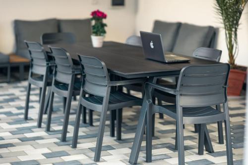 a wooden table with chairs and a laptop on it at ADAMZ in Vama Veche