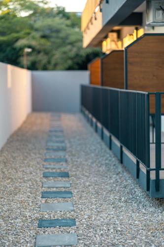 a stone walkway with a fence next to a building at ADAMZ in Vama Veche