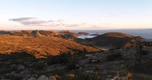 a view of a mountain with the ocean in the background at Quilla Wasi - ISLA DEL SOL in Comunidad Yumani