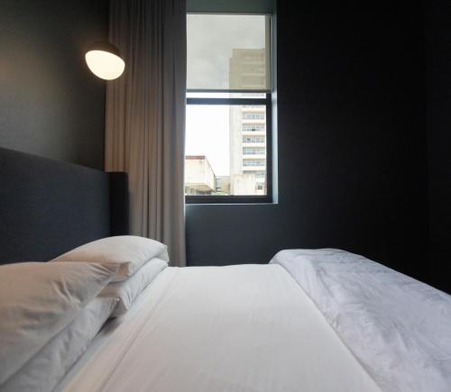 une chambre avec un lit blanc avec une fenêtre dans l'établissement The Thomas Hotel - Premium Suite, à Tyler