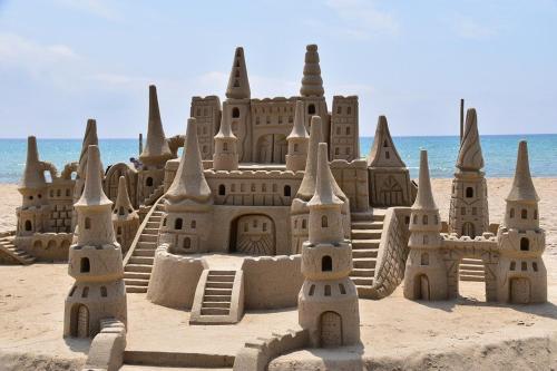 um castelo de areia na praia com o oceano ao fundo em Hostel Ariel Beach Pousada em Mongaguá