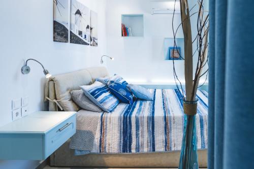 a bedroom with a bed and a vase with pillows at Theoxenia Kasos Luxury Apartments in Panayía