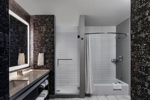 a bathroom with a tub and a sink and a shower at Le Meridien Houston Downtown in Houston