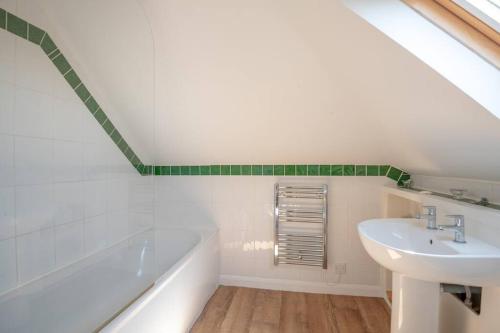 a white bathroom with a sink and a bath tub at Fantastic sea views. One Bedroom flat near the sea in Selsey