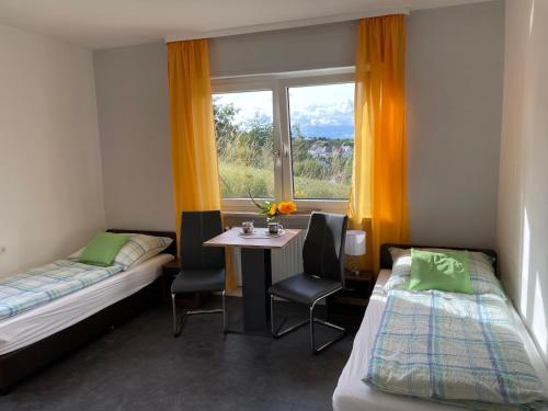 a room with two beds and a table and a window at FERIENWOHNUNG AM BERG in Marktgraitz