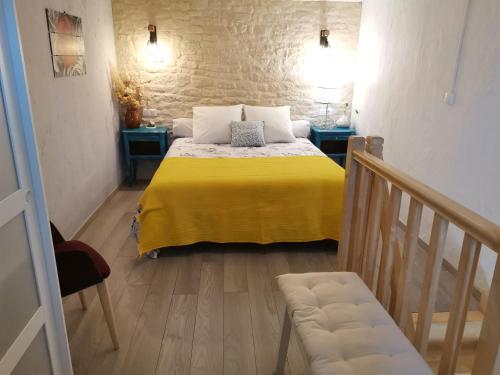 a small room with a bed with a yellow blanket at Gîte en Provence ''Rose'' in Modène