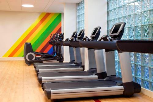 a row of treadmills in a gym with a colorful wall at Sheraton North Houston at George Bush Intercontinental in Houston