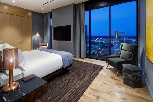 a hotel room with a bed and a chair at The Joseph, a Luxury Collection Hotel, Nashville in Nashville