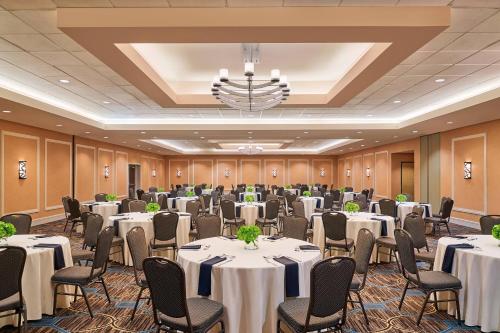 a conference room with tables and chairs and a chandelier at Sheraton North Houston at George Bush Intercontinental in Houston