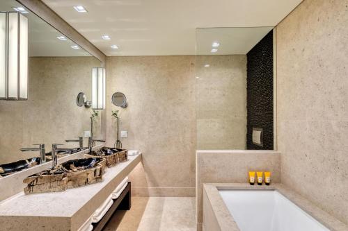 a bathroom with two sinks and a bath tub at Santa Marina, A Luxury Collection Resort, Mykonos in Ornos