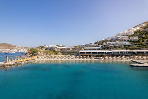 a large body of water with chairs and buildings at Santa Marina, A Luxury Collection Resort, Mykonos in Ornos