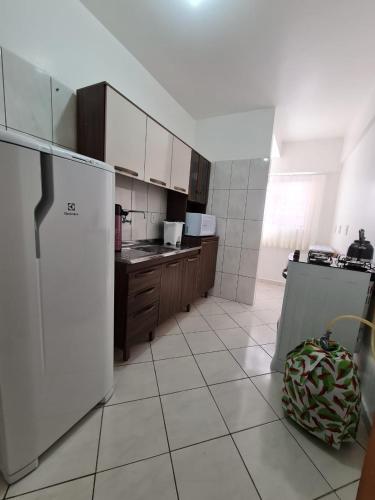 a kitchen with white appliances and a white tiled floor at Apartamento com mobília nova 101! in Francisco Beltrão