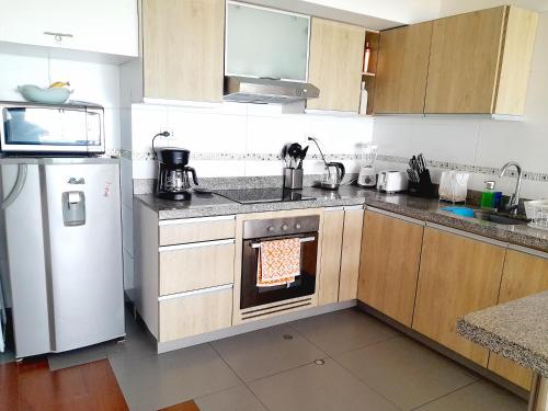 利馬的住宿－Stylish New Apartment with stunning Ocean View near Miraflores，厨房配有炉灶和冰箱。