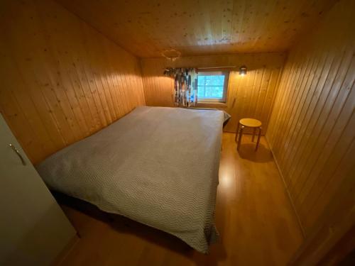 Levin Kätkäläinen B 2, keskustassa 7 hlö huoneisto في ليفي: غرفة نوم صغيرة مع سرير في غرفة خشبية
