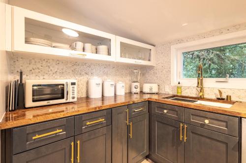 a kitchen with a counter with a microwave and a sink at THE SHORELINE CABIN in Kodiak