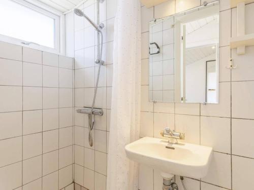 La salle de bains blanche est pourvue d'un lavabo et d'une douche. dans l'établissement Holiday home Vejers Strand XXI, à Vejers Strand