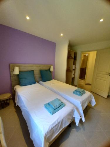 Pierlas的住宿－GITES DE PIERLAS，一间卧室配有两张带蓝色枕头的床
